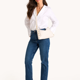 Woman wearing a white blouse and blue jeans on a white background