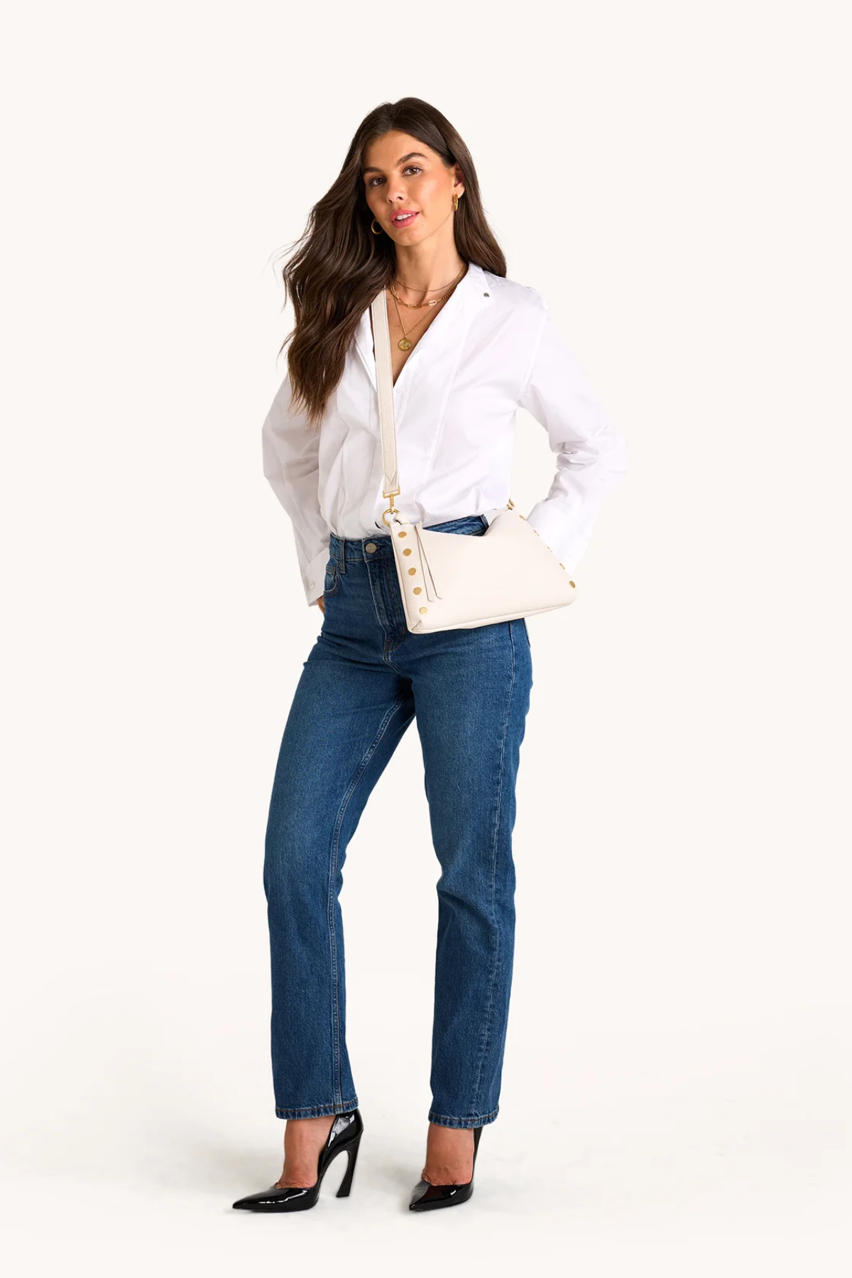 Woman wearing a white blouse and blue jeans on a white background