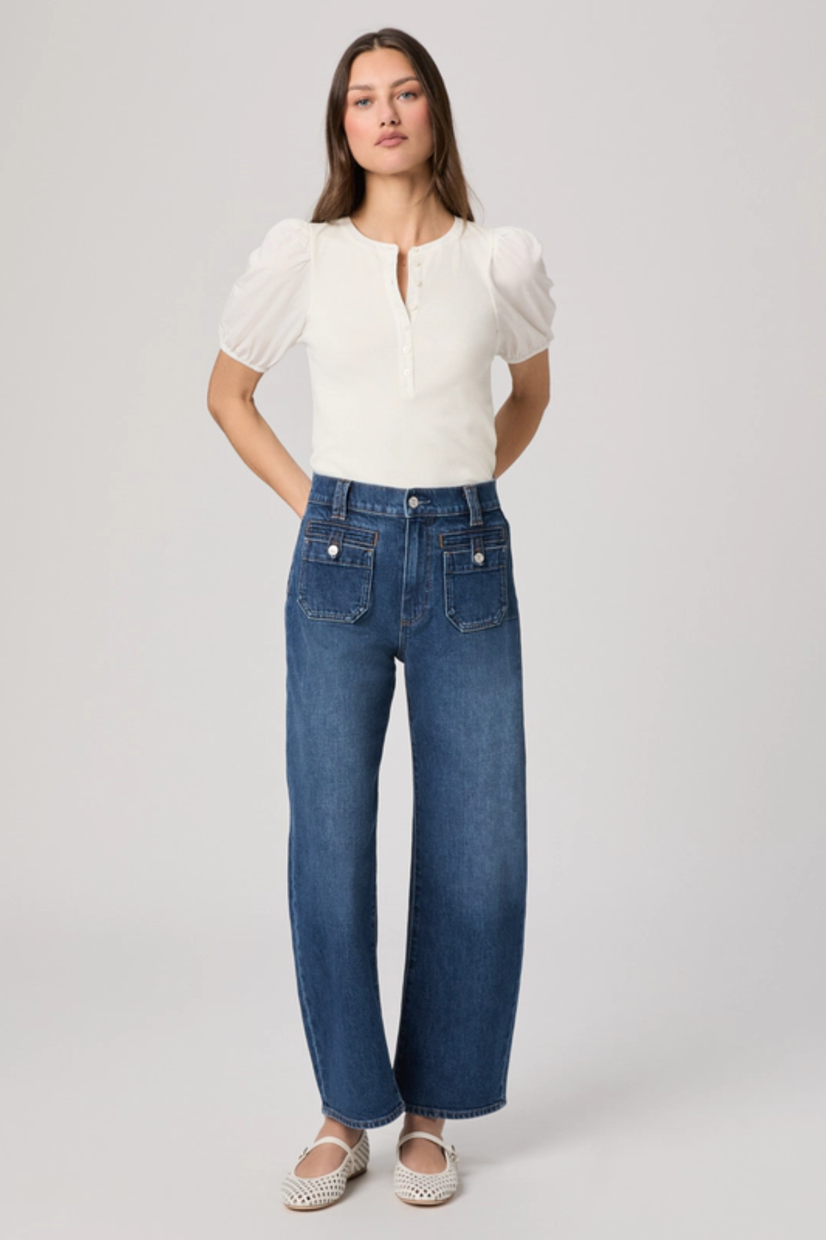 Woman wearing a white blouse and blue jeans on a white background