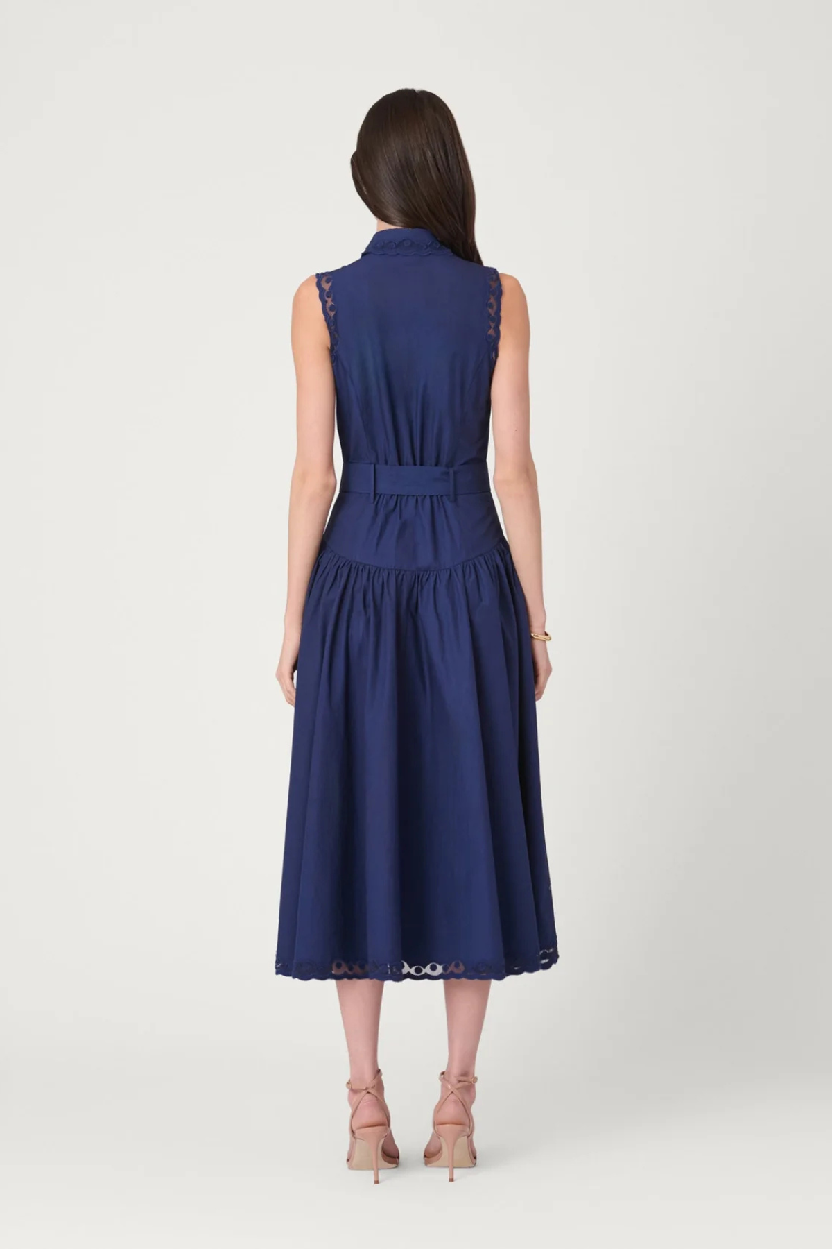 Model wearing a sleeveless midi dress with a fitted bodice and feminine, timeless silhouette.