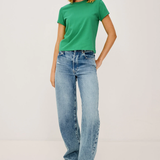 Woman wearing a green t-shirt and blue jeans on a white background