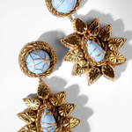 Blue and gold drop earrings on a white background.