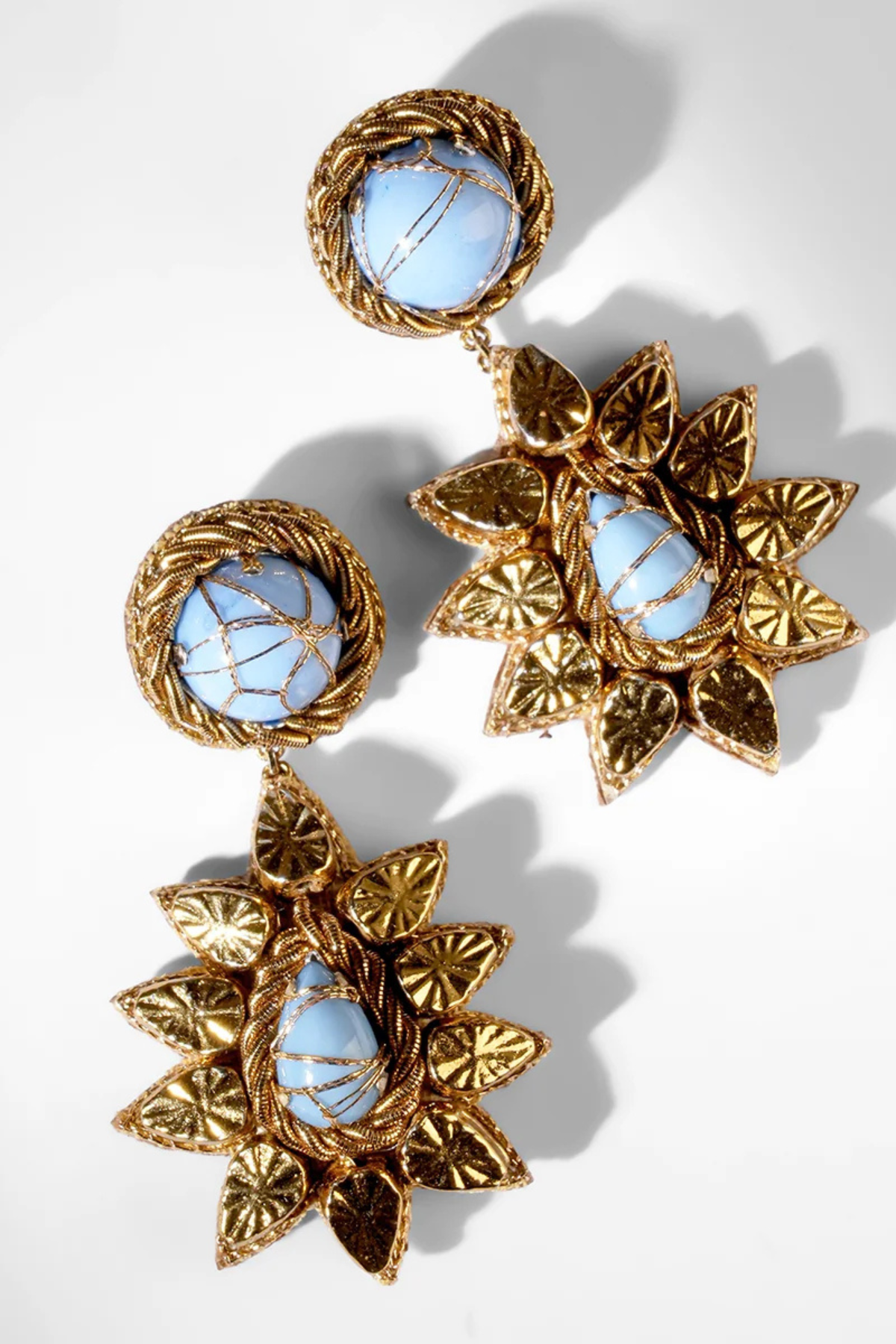 Blue and gold drop earrings on a white background.