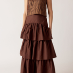 Woman wearing a brown tiered dress with a textured top against a white background