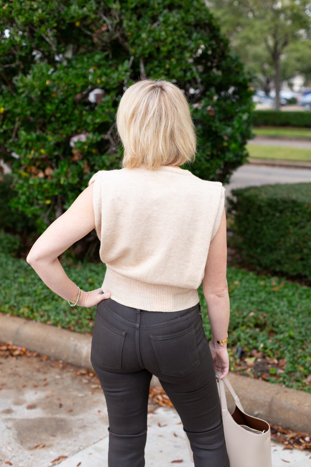 Sleeveless knit muscle sweater vest styled with trousers