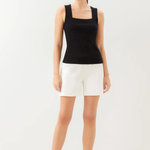 Woman wearing a black tank top and white shorts on a white background