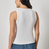 Model wearing a white sleeveless V-neck knit tank with blue denim.