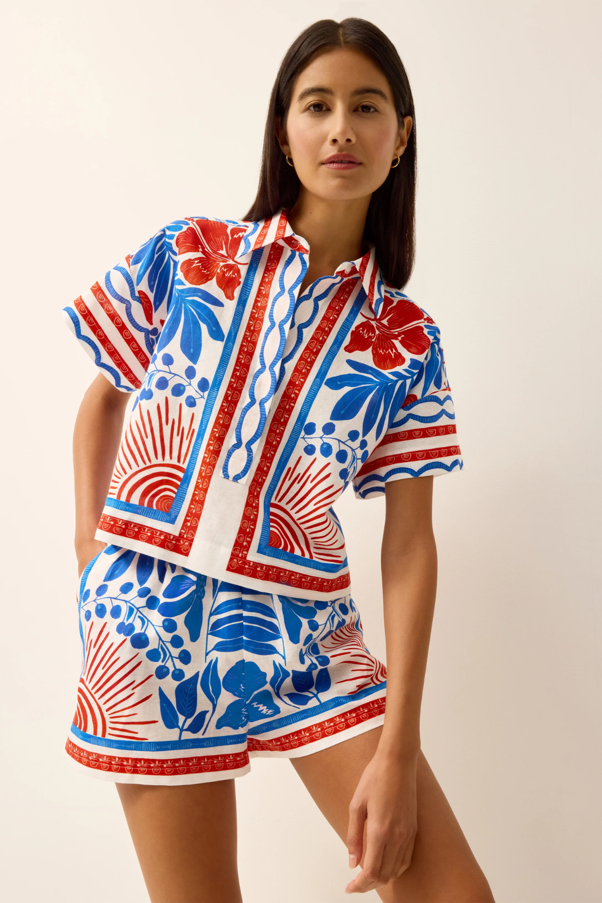 Woman wearing a colorful patterned outfit on a plain background