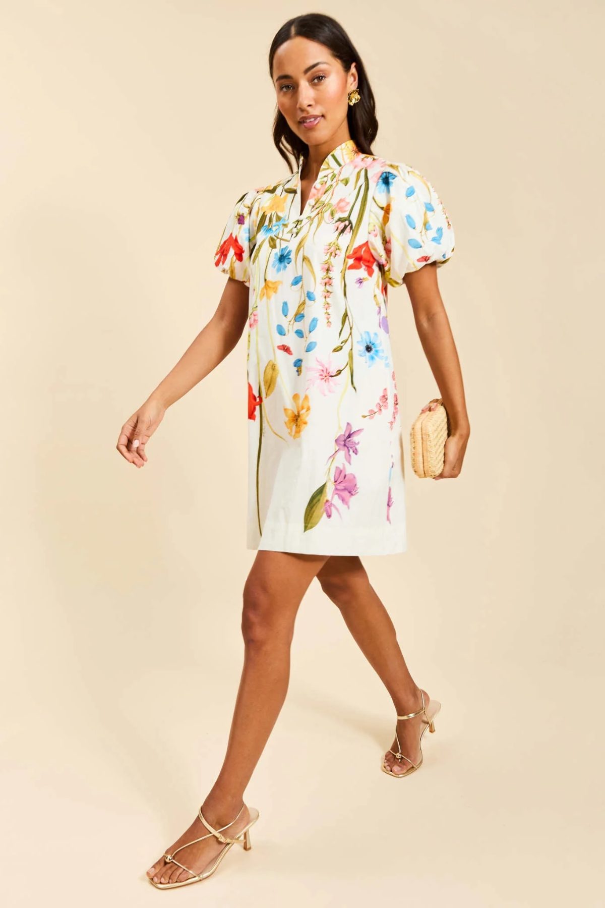 Woman wearing a colorful floral dress on a beige background