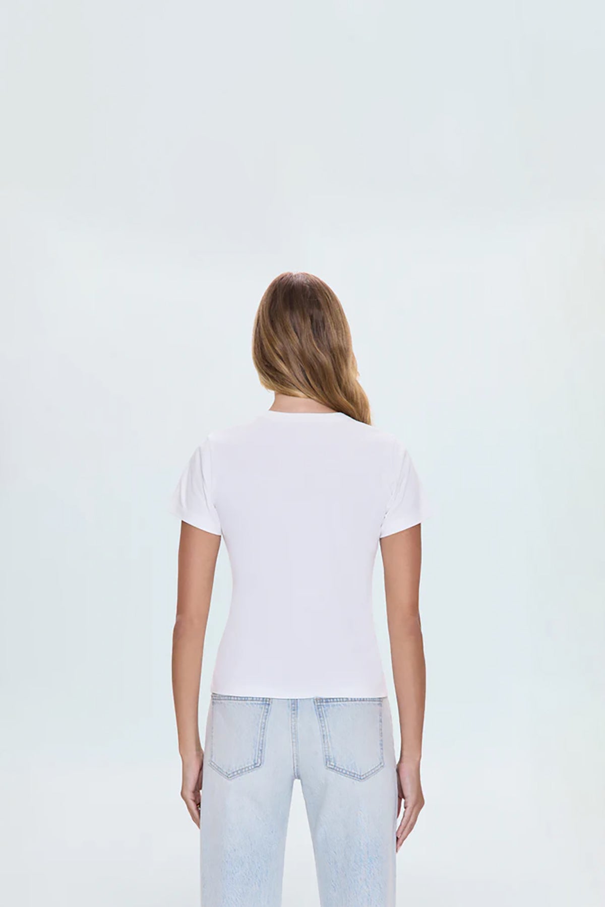 Minimal white top with a clean neckline and streamlined fit.