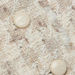Close-up of a textured fabric surface with two buttons.