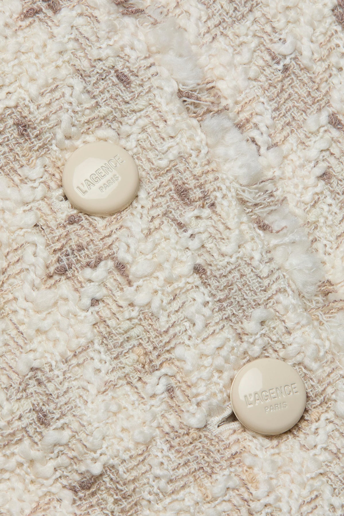 Close-up of a textured fabric surface with two buttons.