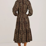 Woman wearing a leopard print dress on a white background