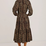 Woman wearing a leopard print dress on a white background