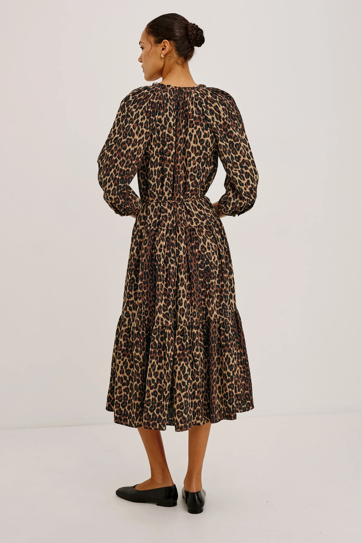 Woman wearing a leopard print dress on a white background