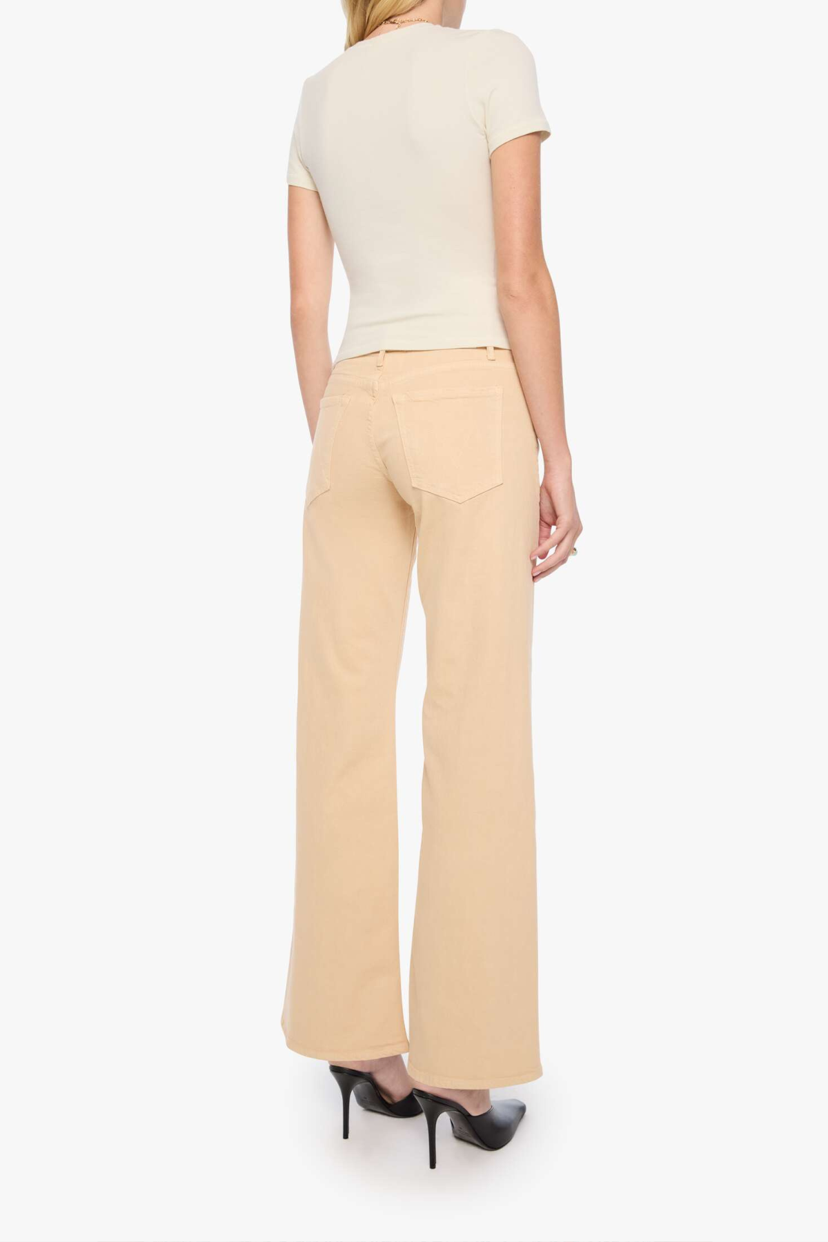 A model shown from the back wearing beige wide-leg pants, a cream short-sleeve top, and black high heels against a plain white background.