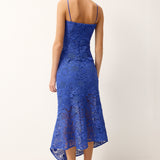 Woman wearing a blue lace dress on a white background