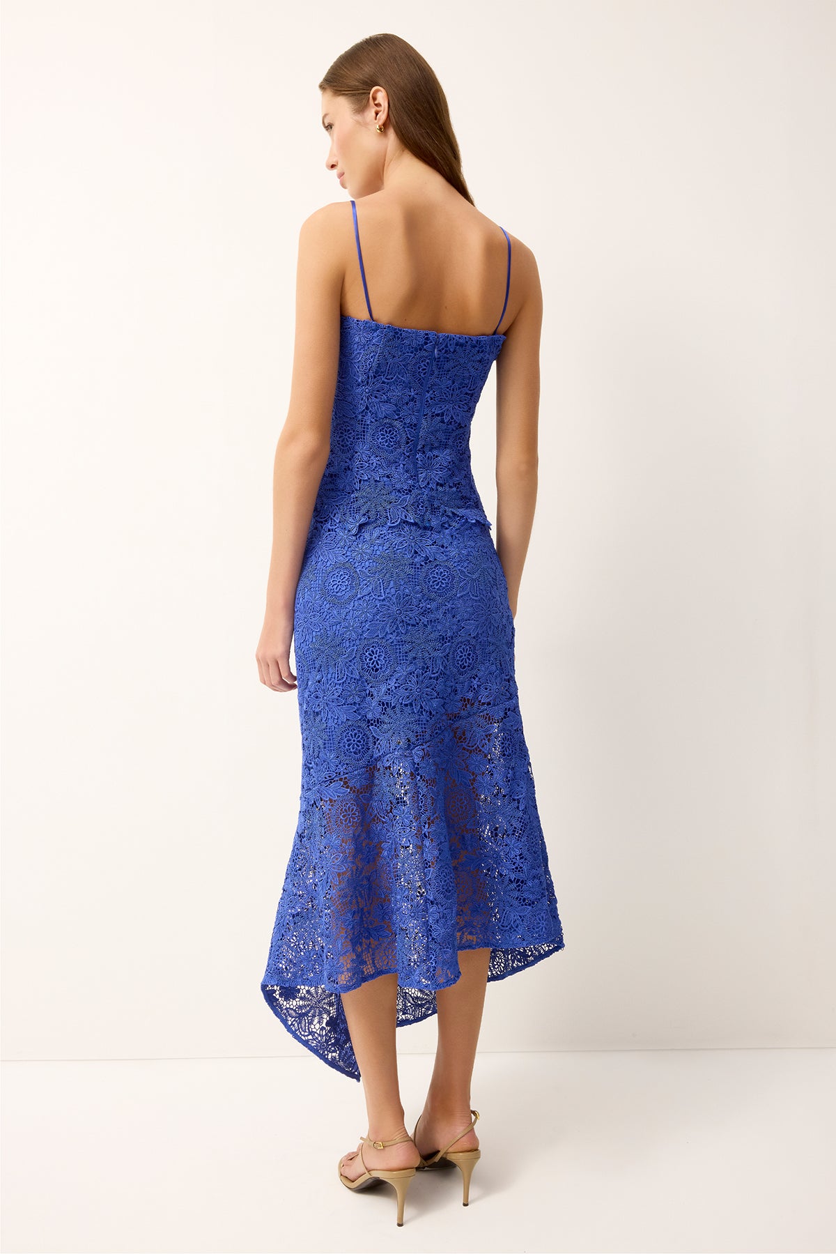 Woman wearing a blue lace dress on a white background