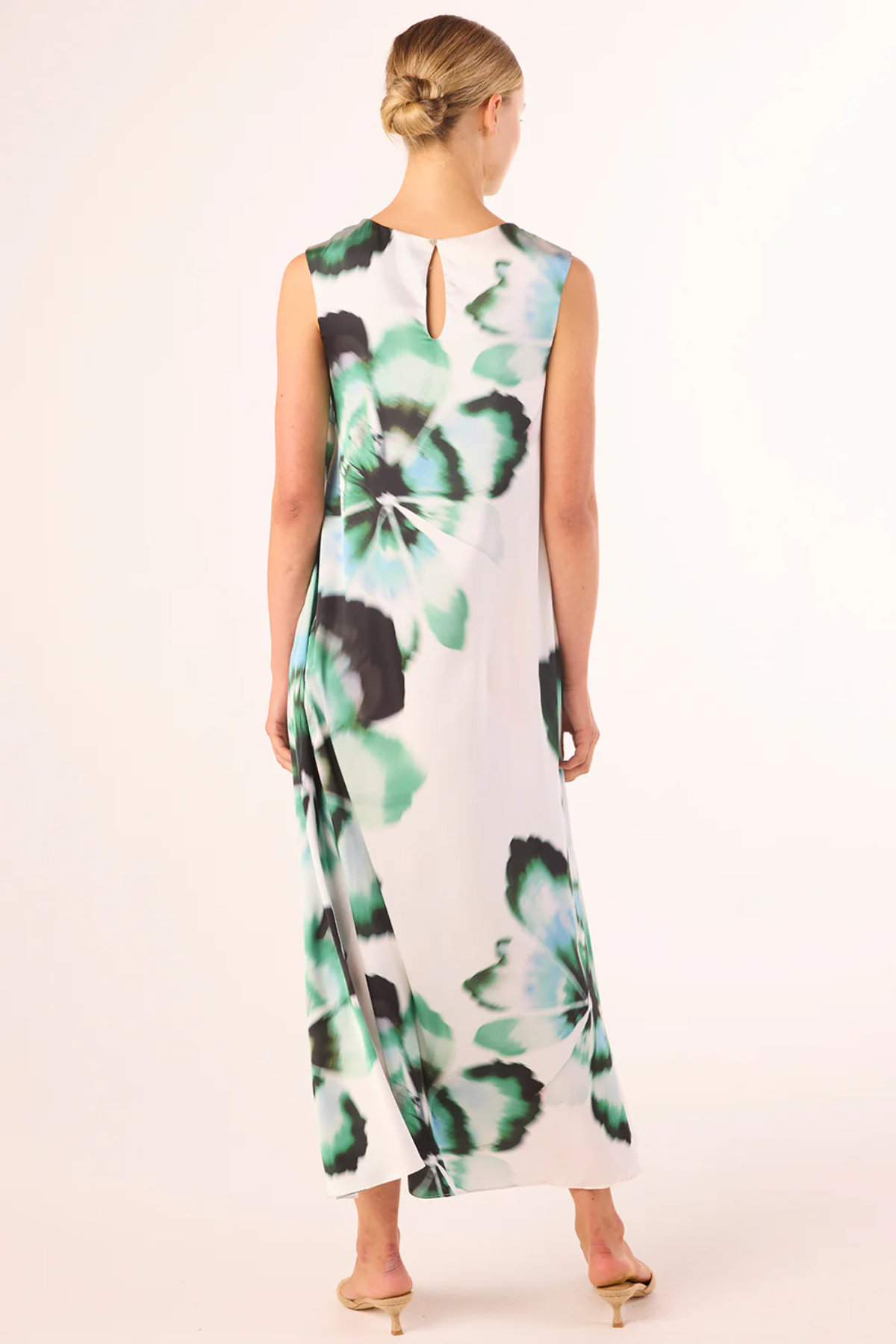 back of woman in floral printed dress on white background 