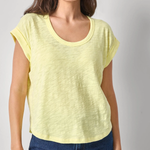 Woman wearing a yellow top and blue jeans against a plain background