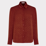 A rust-red long-sleeve button-up shirt with a fine white micro-dot pattern, displayed on a light gray background.