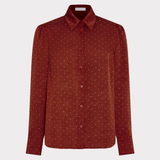 A rust-red long-sleeve button-up shirt with a fine white micro-dot pattern, displayed on a light gray background.