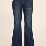 Medium wash blue denim flare jeans with decorative gold-tone metal studs down the outer sides of the thighs, shown on a model from the waist down against a plain beige background.