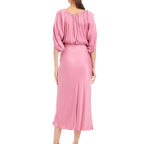 Woman wearing a pink dress with balloon sleeves on a white background