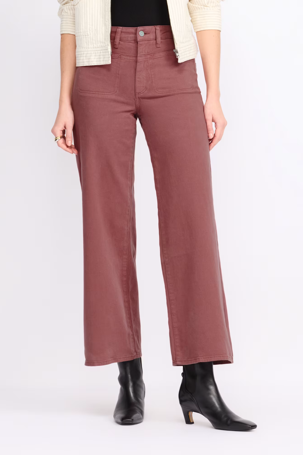 A model is wearing a pair of wide-leg cropped pants in a dusty rose or mauve color, styled with a cream cardigan, black top, and black ankle boots against a plain white studio background.