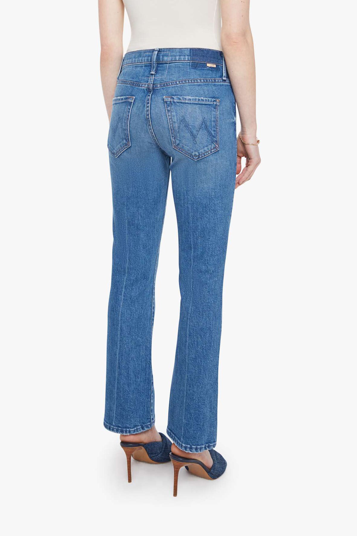 Woman wearing mid-wash cropped flare jeans with a slim upper fit and subtle kick-flare hem.