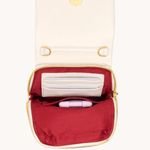 Small pouch with a red interior and gold zipper, containing a white item and a pink item on a white background.