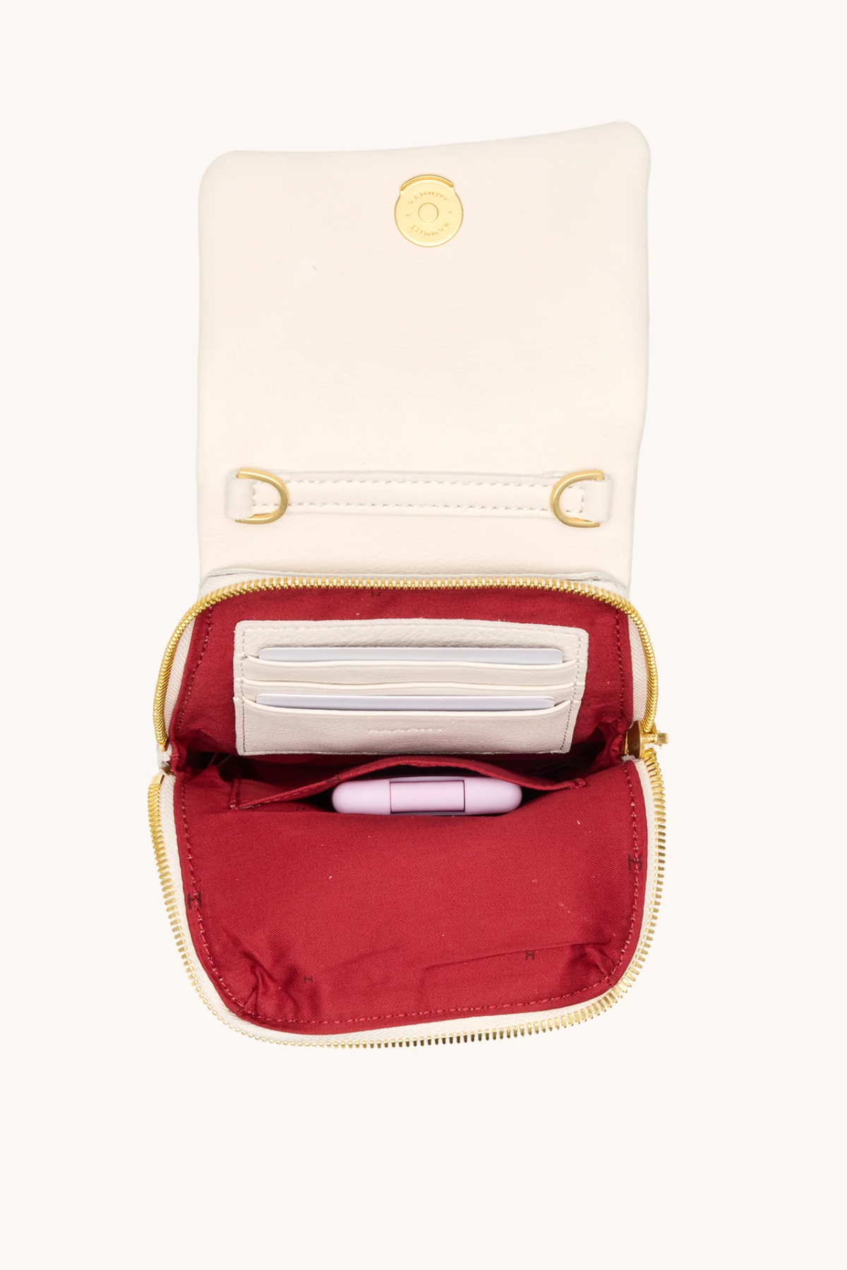 Small pouch with a red interior and gold zipper, containing a white item and a pink item on a white background.