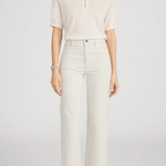 woman in white top and stripe pants on white background 