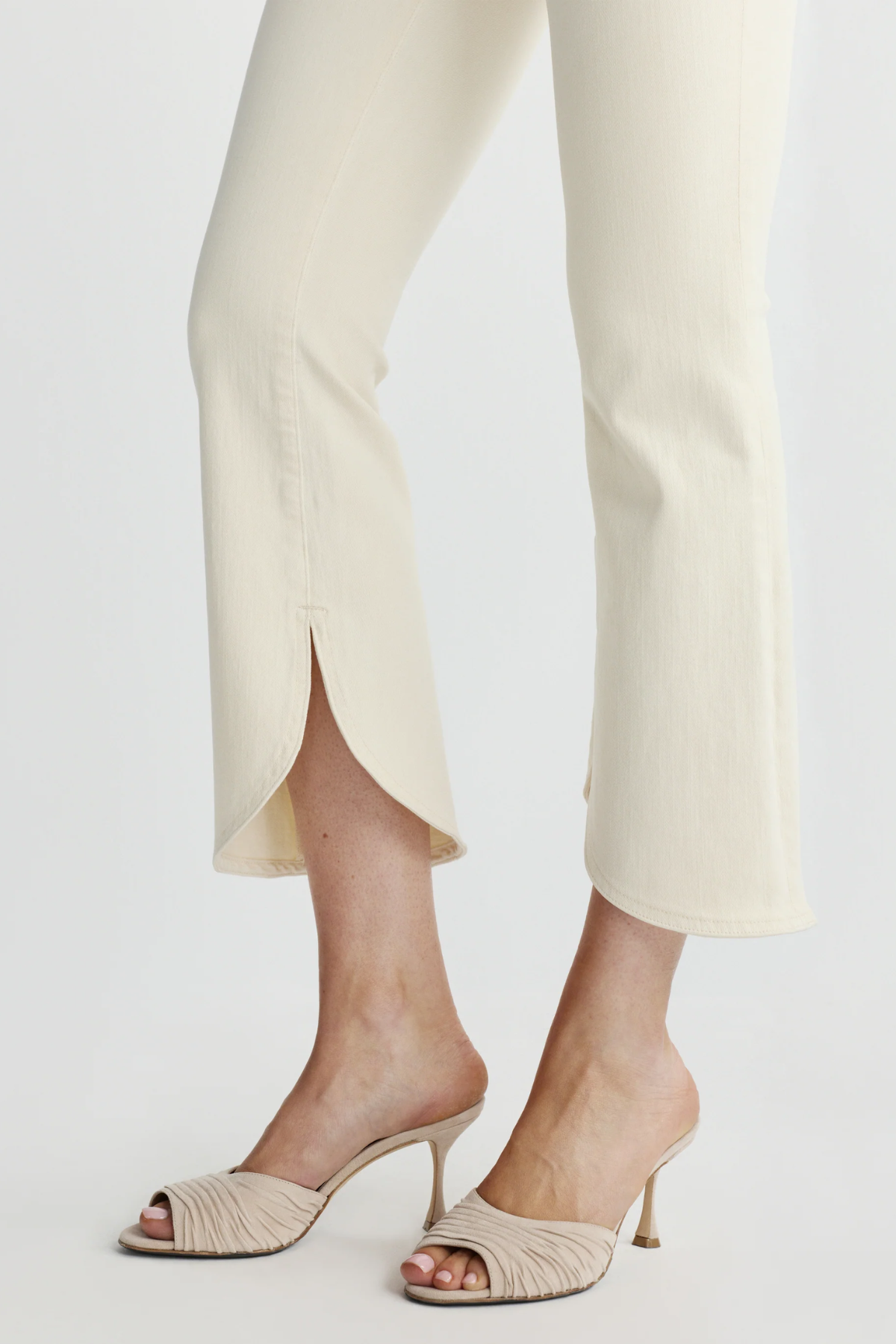 close up on scalloped cream denim and textured heels 