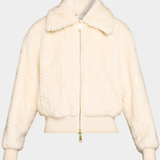 A cream-colored faux fur jacket with a gold zipper, shown against a light gray background.