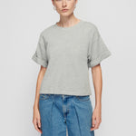 Person wearing a gray t-shirt and blue jeans on a white background