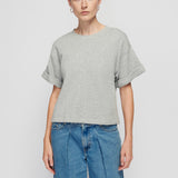 Person wearing a gray t-shirt and blue jeans on a white background