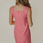 Red and white checkered dress worn by a person on a plain background