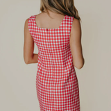 Red and white checkered dress worn by a person on a plain background