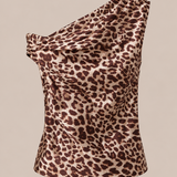 A one-shoulder leopard print top with a draped, gathered neckline, shown against a solid beige background.