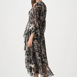 Woman wearing a long, patterned dress on a white background