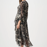 Woman wearing a long, patterned dress on a white background