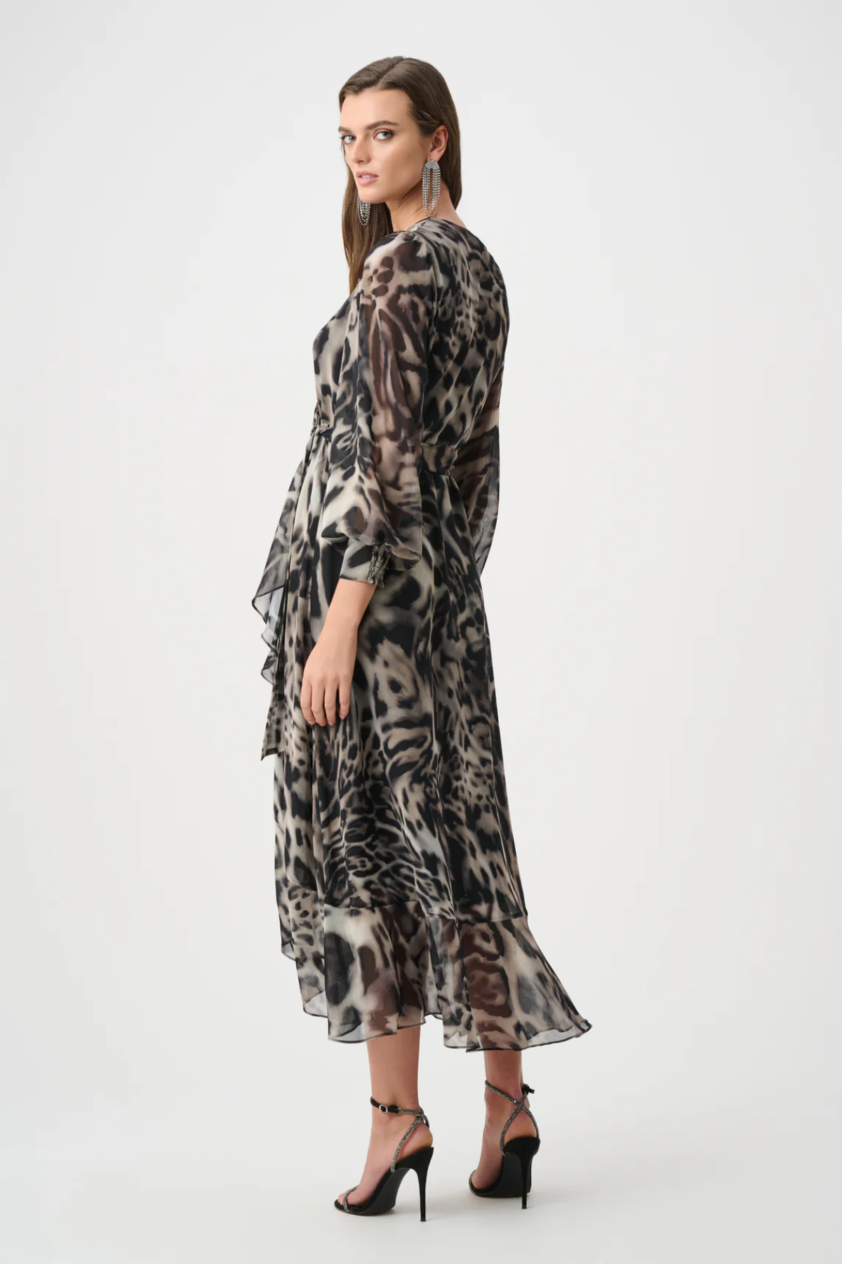 Woman wearing a long, patterned dress on a white background