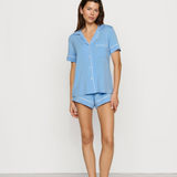Woman wearing a light blue pajama set against a white background