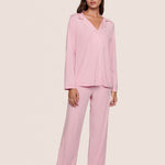 Woman wearing pink pajamas against a plain background