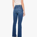 A woman shown from the back wearing blue high-rise flare jeans, a cream short-sleeve top, and metallic high heels against a plain white background.