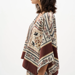 Woman wearing a patterned kimono-style garment on a white background