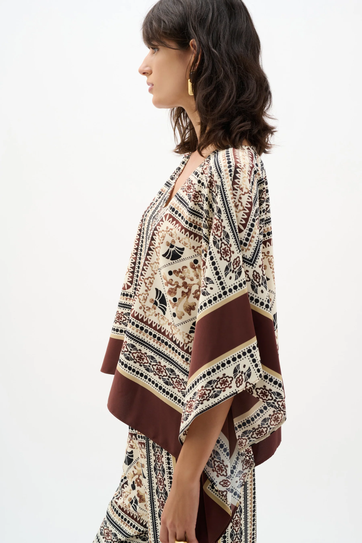 Woman wearing a patterned kimono-style garment on a white background