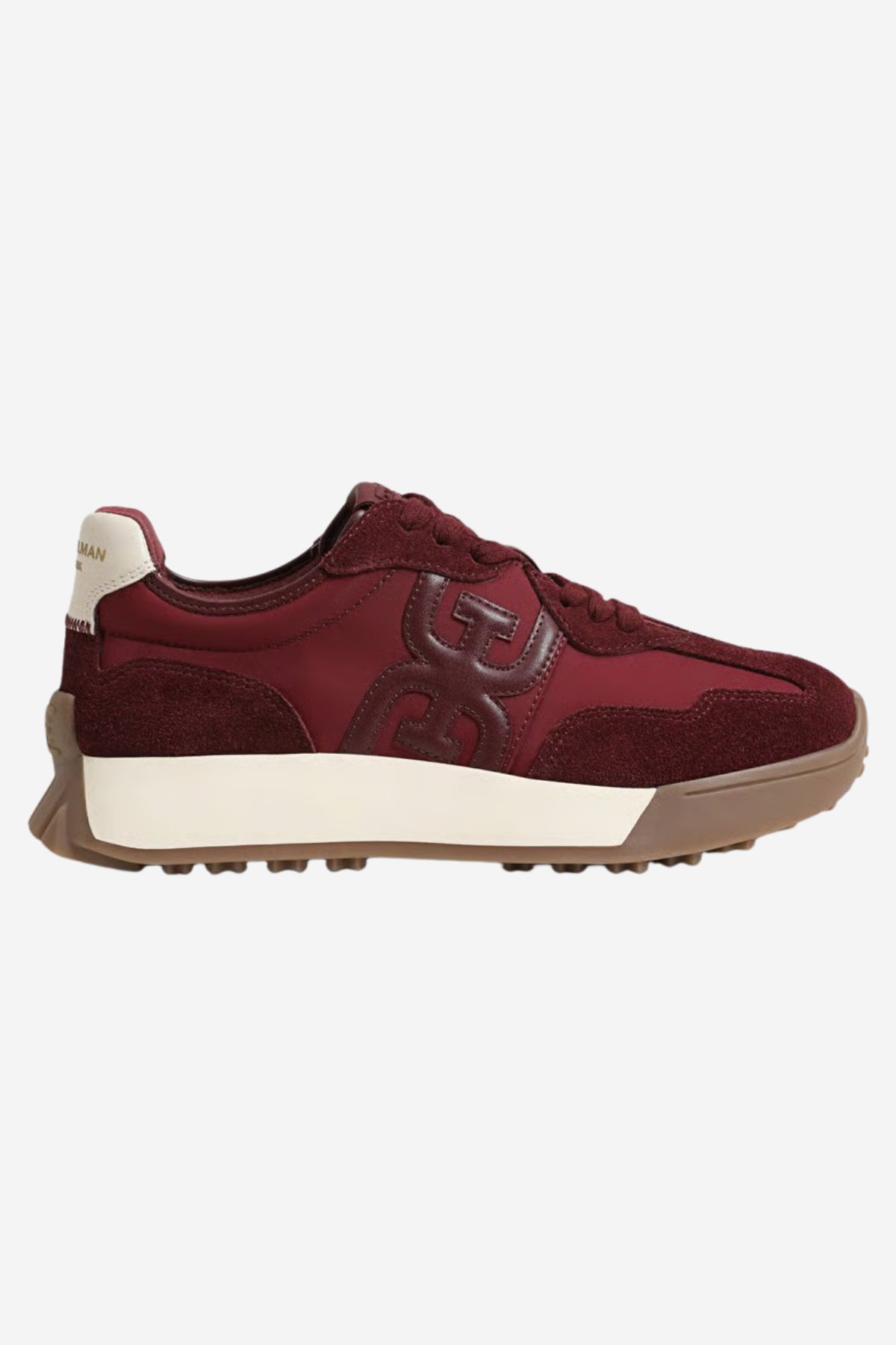 A low-top sneaker in burgundy suede and leather with a cream midsole and a brown gum outsole, shown from the side on a light gray background.