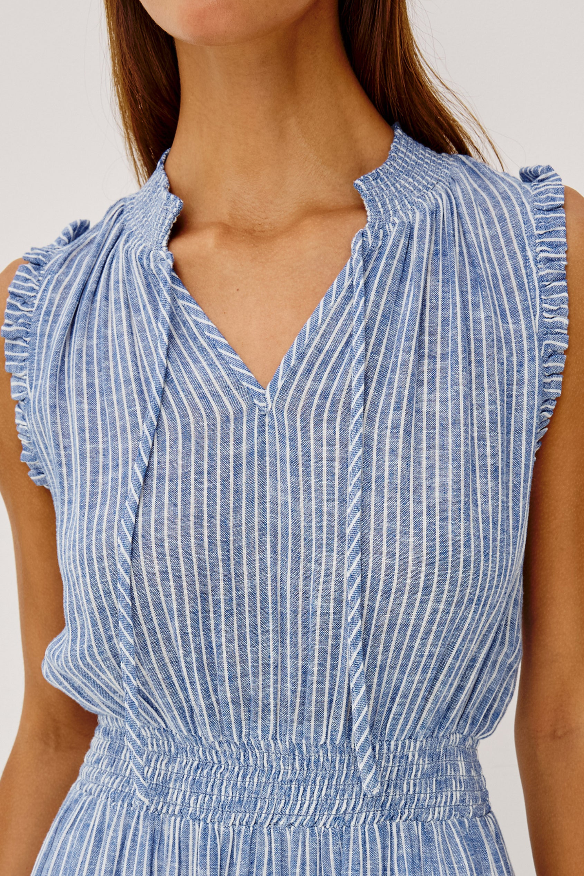 Blue and white striped dress with ruffled shoulders on a plain background